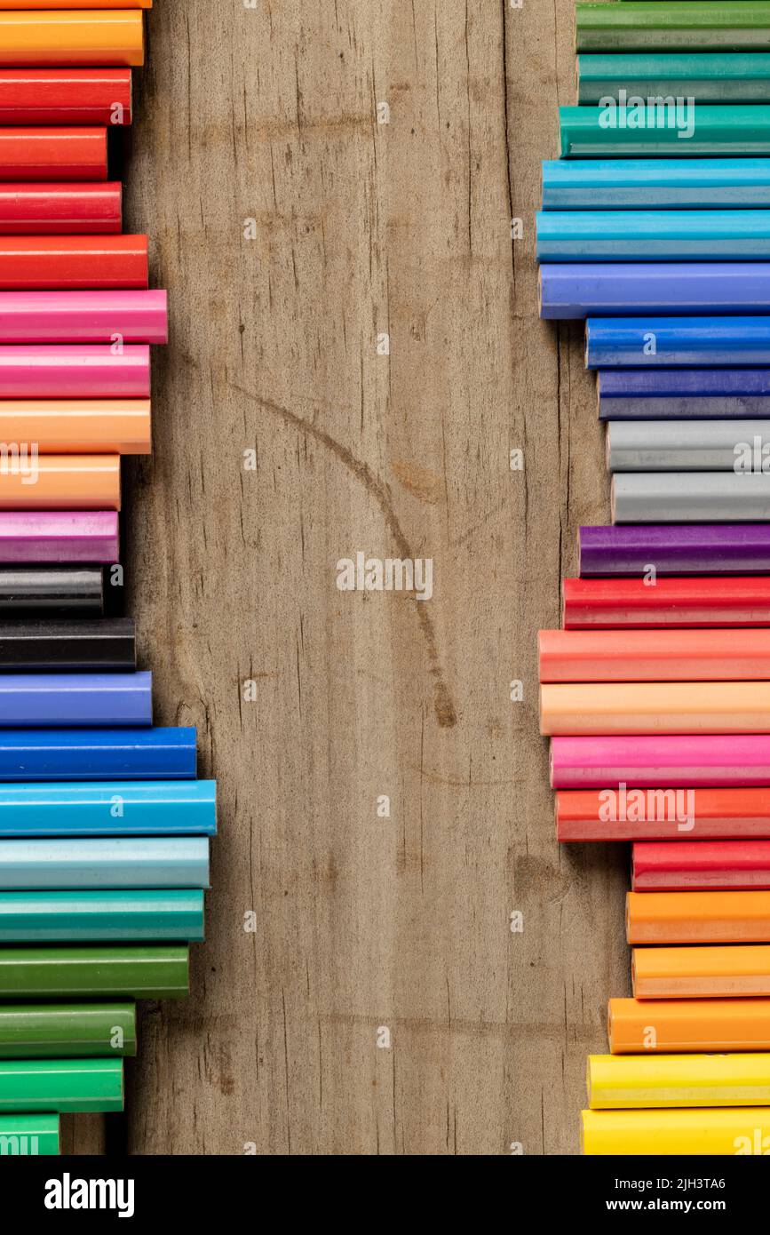 Vertikale Komposition von bunten Buntstiften auf Holzhintergrund Stockfoto