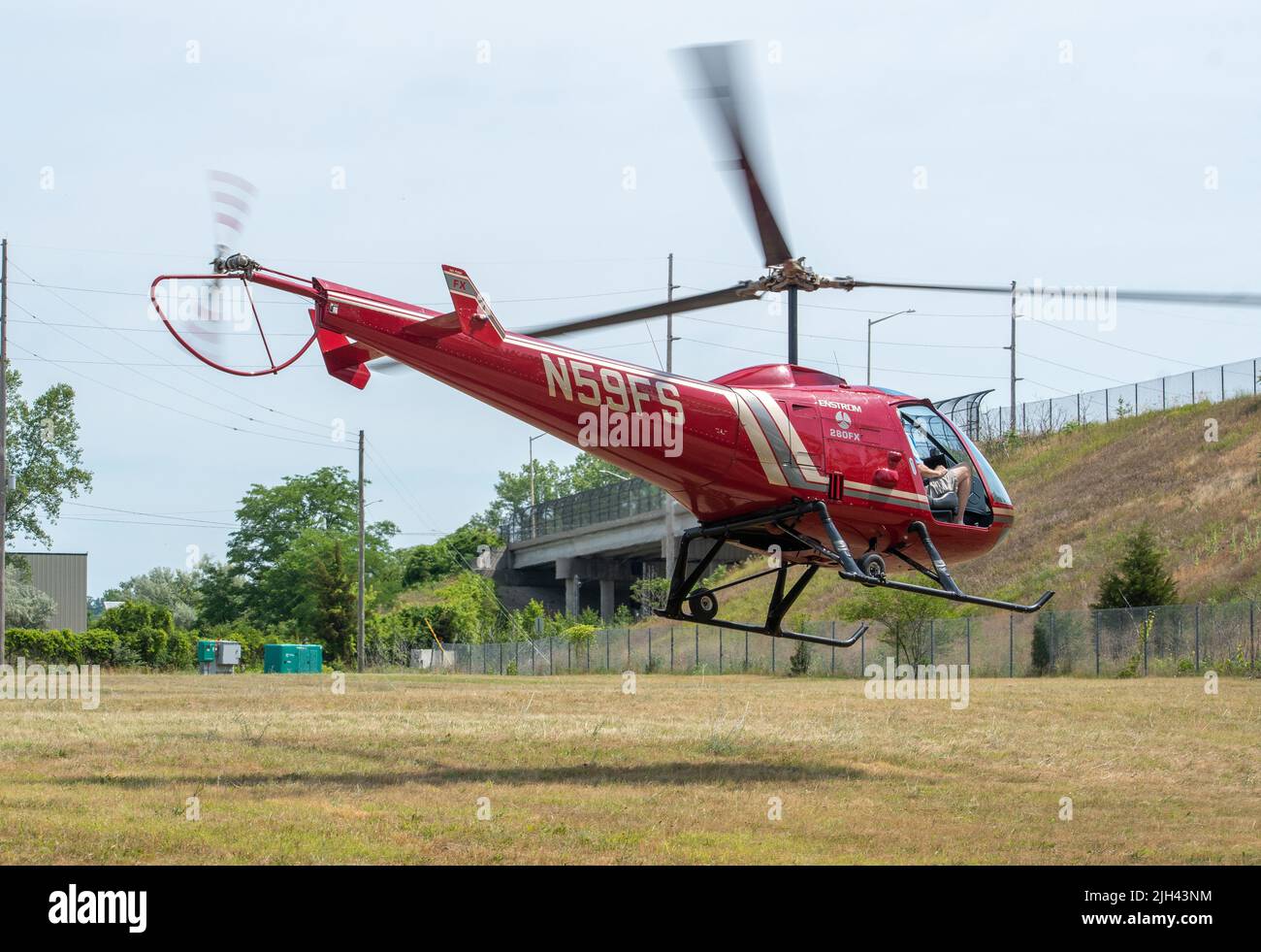 20 2021. juni, St Joseph MI USA ; Ein roter Hubschrauber landet auf einer Wiese, nachdem er einem glücklichen Mann während einer Flugshow einen Flug gegeben hat Stockfoto