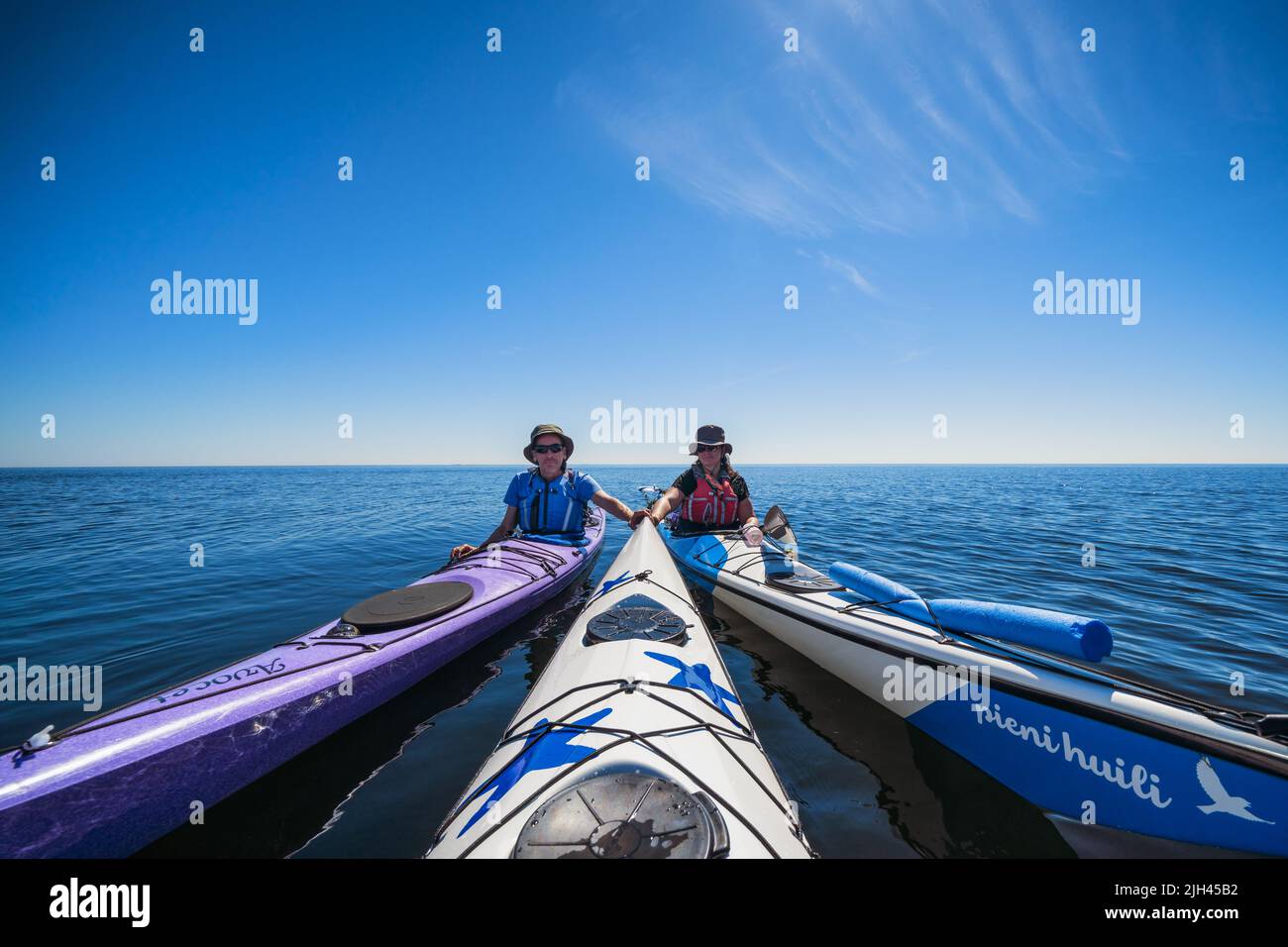 Kajakfahrer, die eine kurze Pause in der Nähe der Insel Ulko-Tammio, Hamina, Finnland, machen Stockfoto