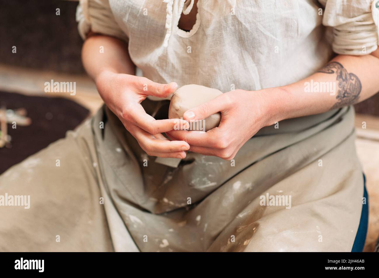 Potter hält einen Klumpen Ton in den Händen Stockfoto