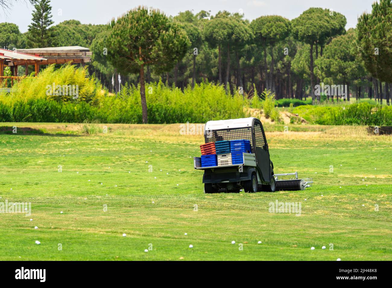 Golfplatz und Golfwagen sammeln Golfbälle. Ballpicker auf Driving Range des Golfclubs Stockfoto