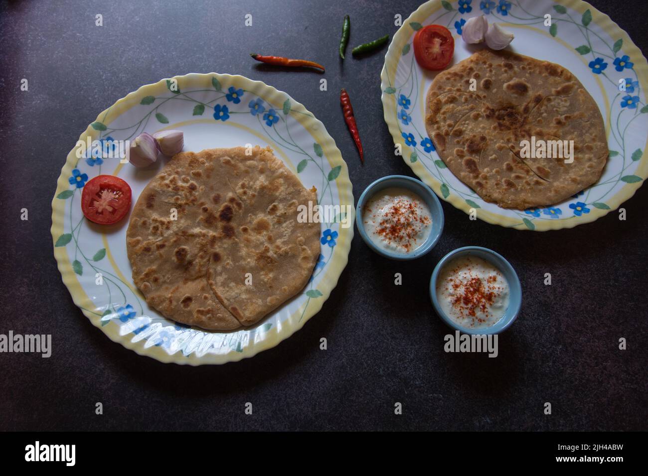 Es wird ein indisches Frühstück mit Aloo Paratha oder gefülltem Fladenbrot mit Kartoffeln serviert. Draufsicht Stockfoto
