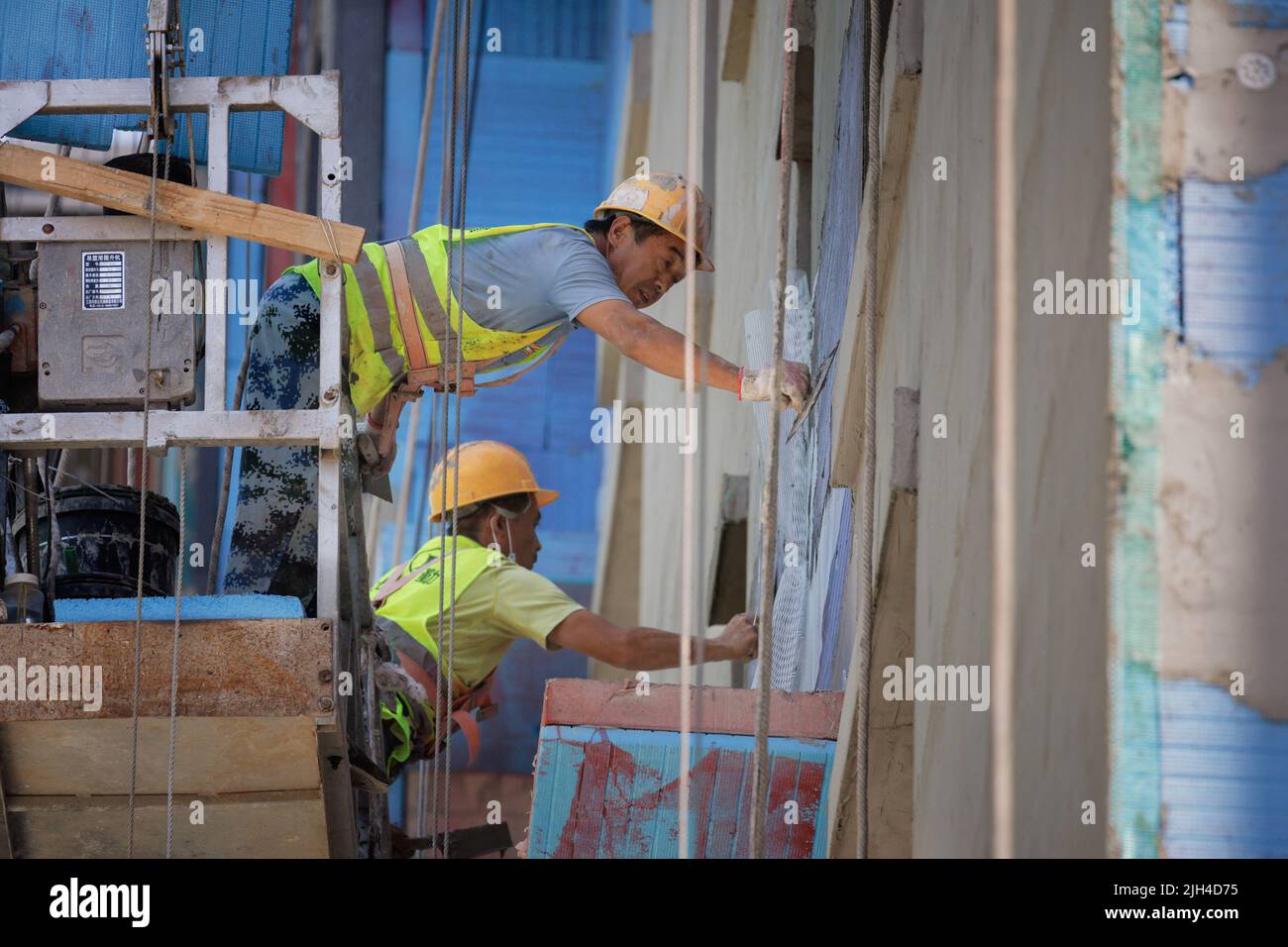 Männer arbeiten auf einer Baustelle von Wohngebäuden in Peking, China, 15. Juli 2022. REUTERS/Thomas Peter Stockfoto