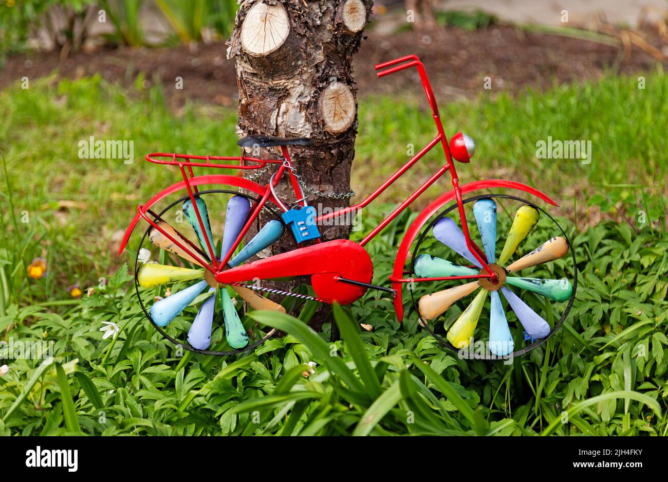 Sehr kleines buntes Fahrrad mit Kette in einem Baum verschlossen Stockfoto