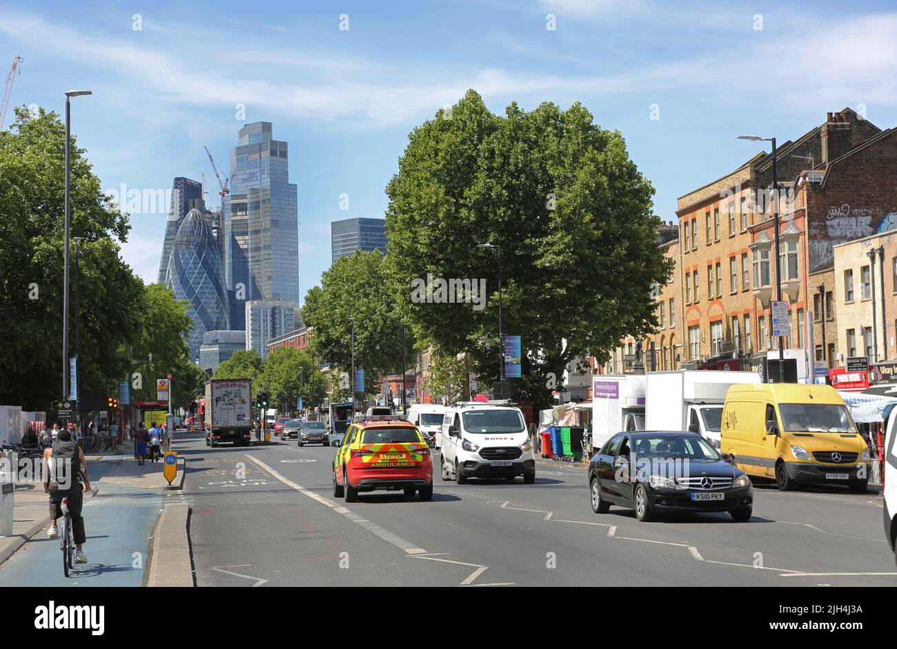 Blicken Sie auf der Mile End Road neben der Whitechapel Station nach Westen in Richtung City of London. Zeigt viel Verkehr, Fahrradweg und Stadttürme dahinter. Stockfoto