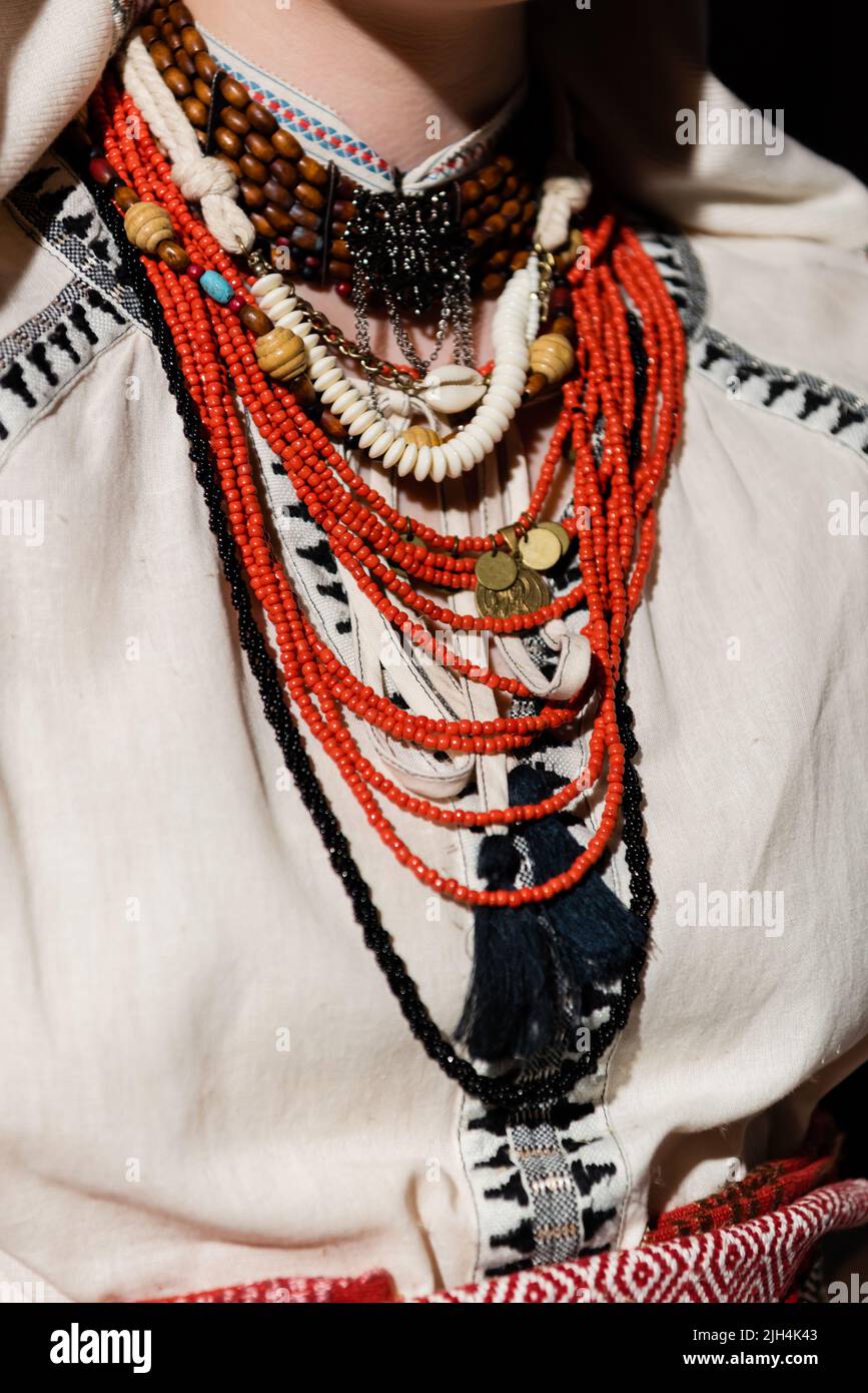Abgeschnittene Ansicht der ukrainischen Frau in traditioneller Kleidung mit Ornament und roten Perlen Stockfoto