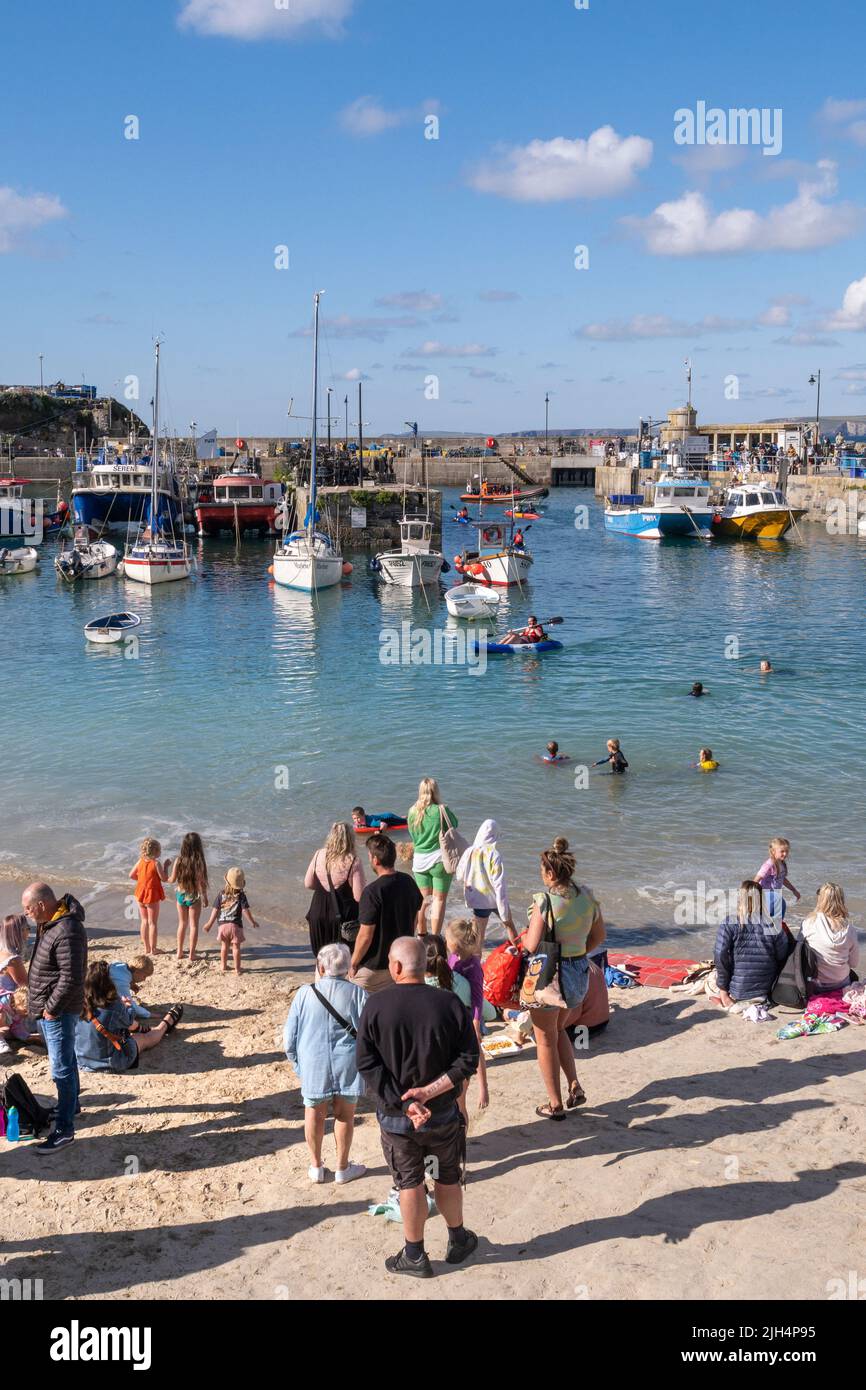 Sommerurlauber, die sich am kleinen Strand von Newquay Harbour in Cornwall in Großbritannien Vergnügen. Stockfoto