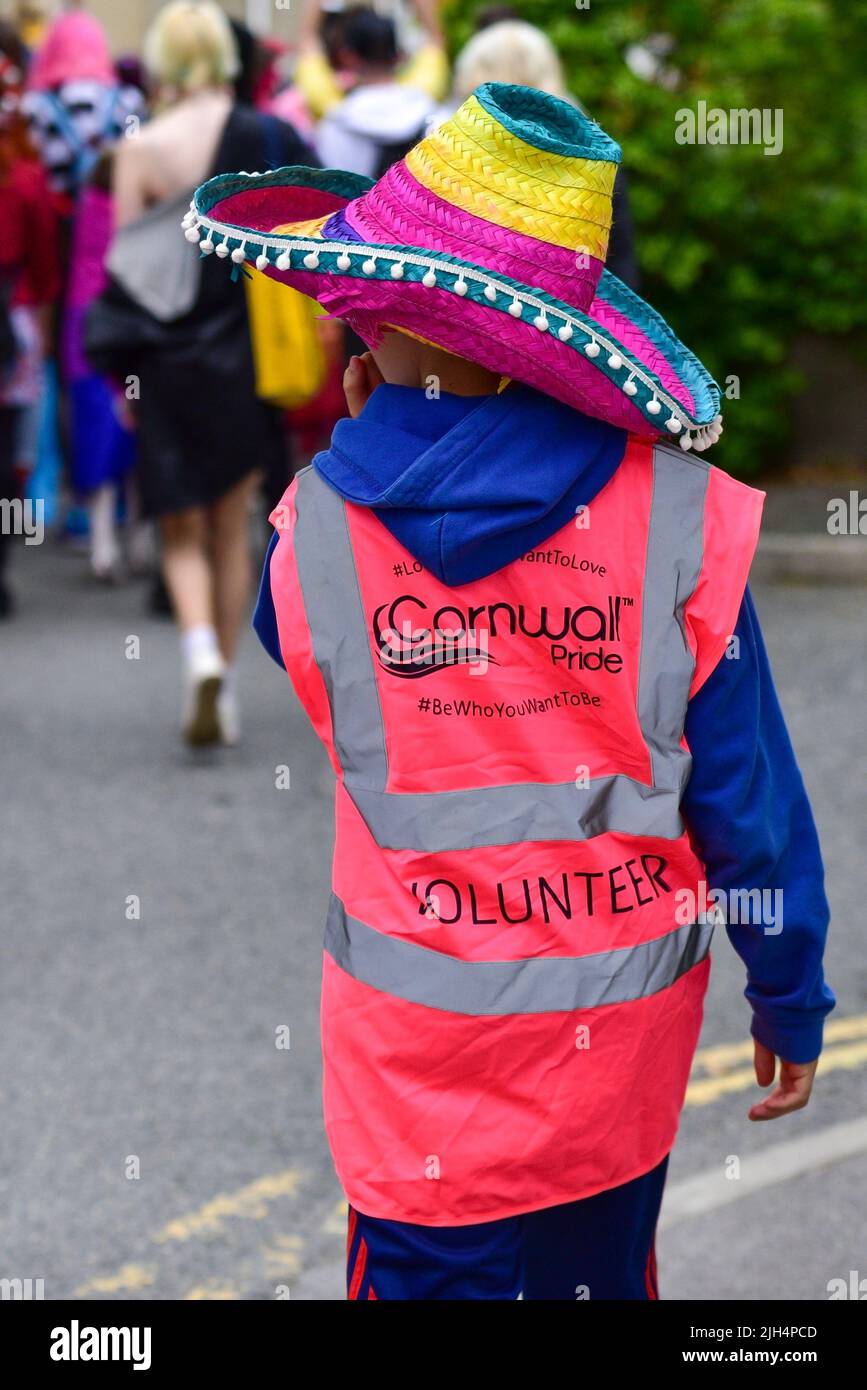 Ein junger ehrenamtlicher Steward bei der farbenfrohen Cornwall Prides Pride Parade im Zentrum von Newquay in Großbritannien. Stockfoto