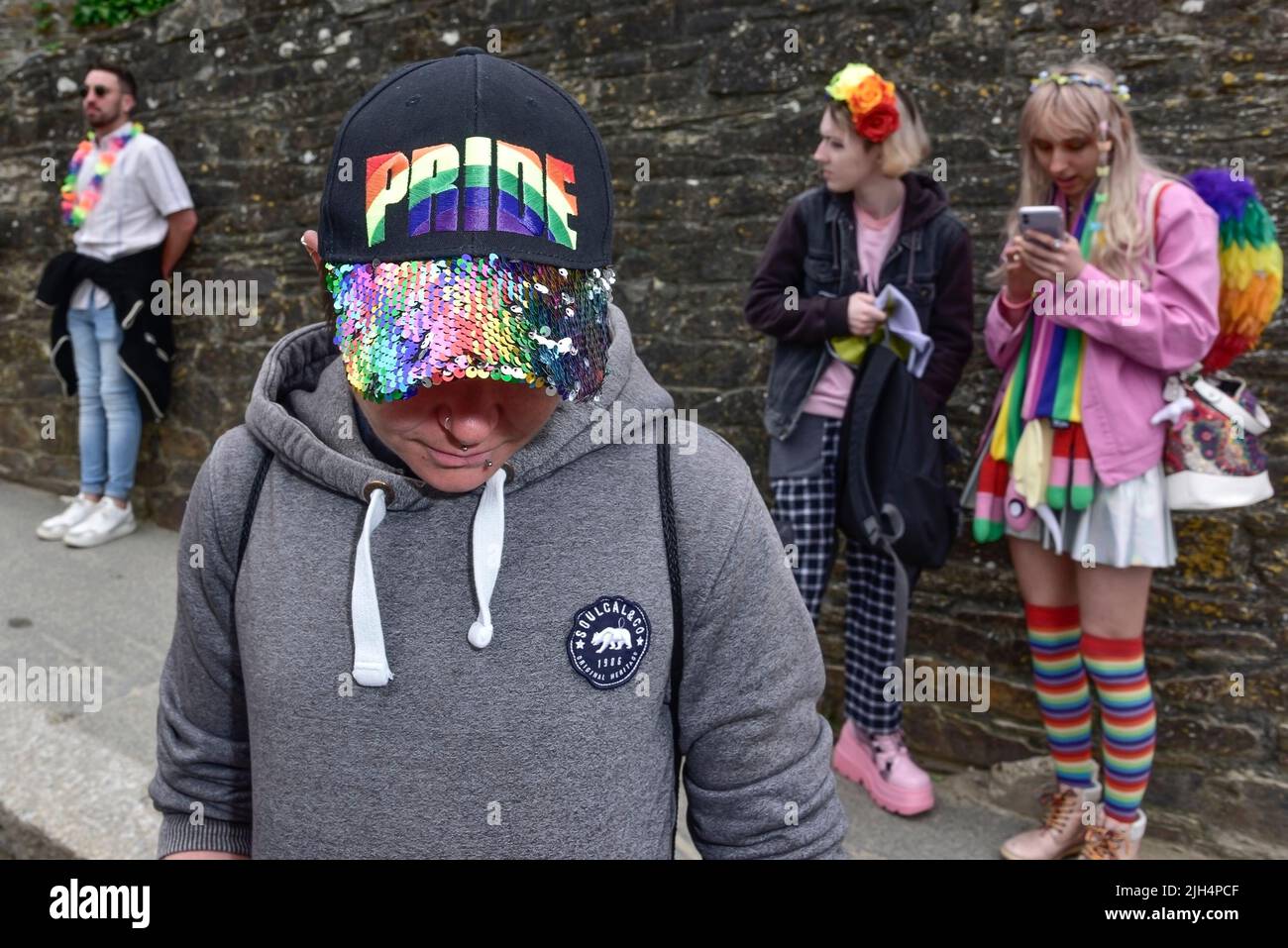 Ein Teilnehmer mit einer farbenfrohen Baseballmütze bei der lebhaften Cornwall Prides Pride Parade im Zentrum von Newquay in Großbritannien. Stockfoto