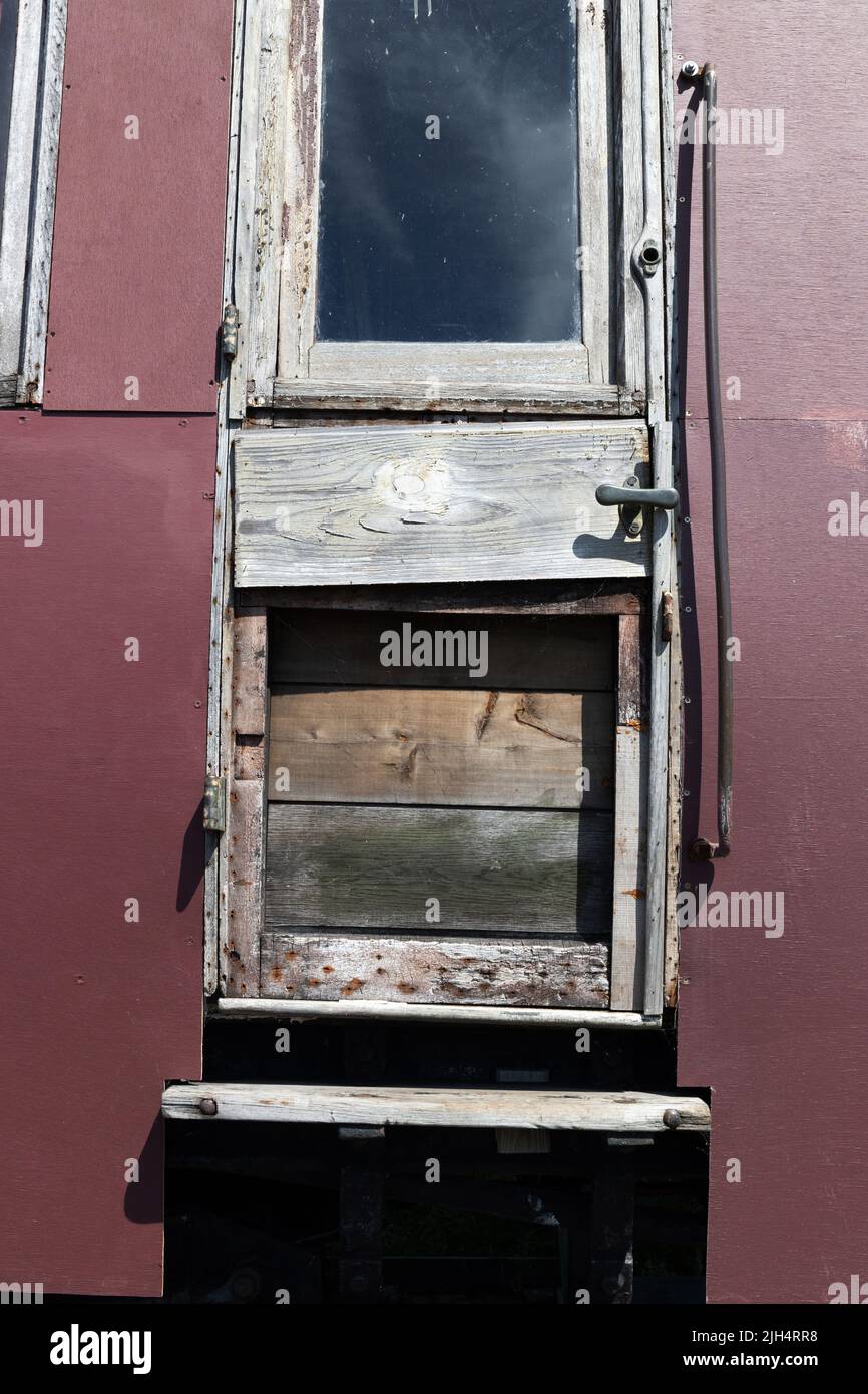 Alte unrestaurierte hölzerne Zugtür mit Fenster Stockfoto