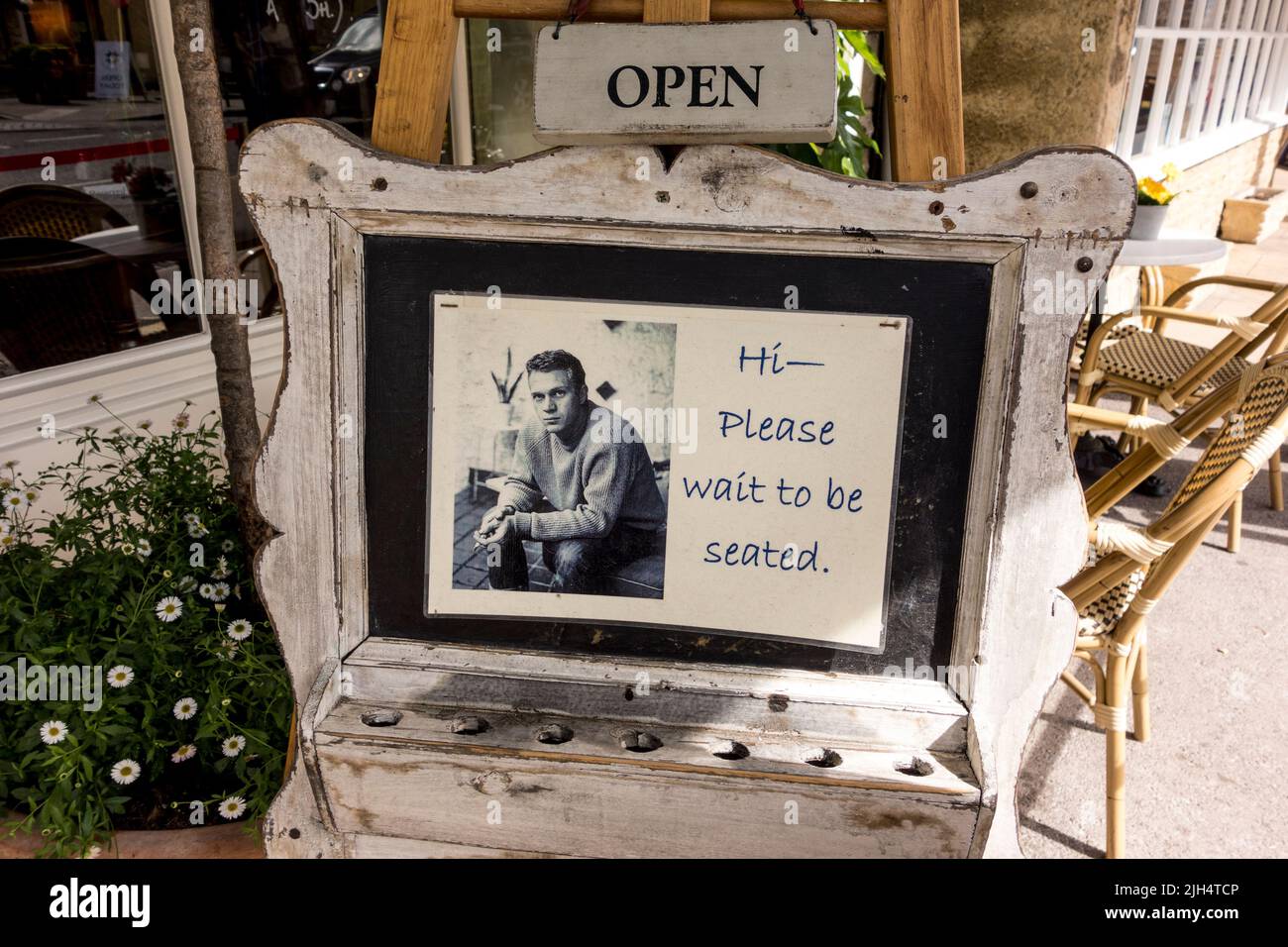 Schild, das Kunden bittet, am Eingang des Cafés, Tetbury, Gloucestershire, Großbritannien, einen Sitzplatz zu erwarten Stockfoto