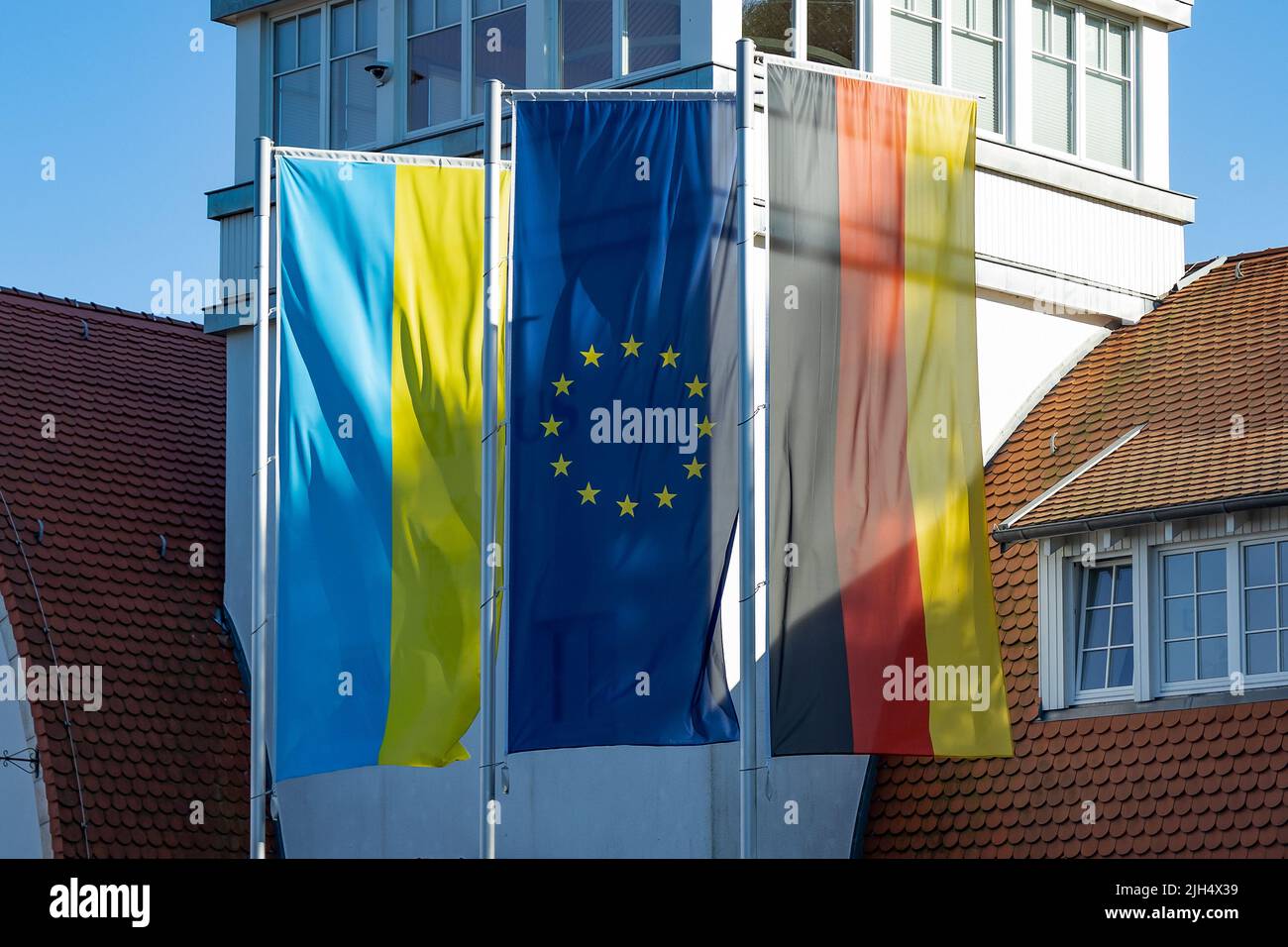 Die Flaggen aus der Ukraine, Europa und Deutschland wurden mitten in einem Ferienort (Boltenhagen) erhoben. Solidarität, Mitgefühl und Stehen zusammen Stockfoto