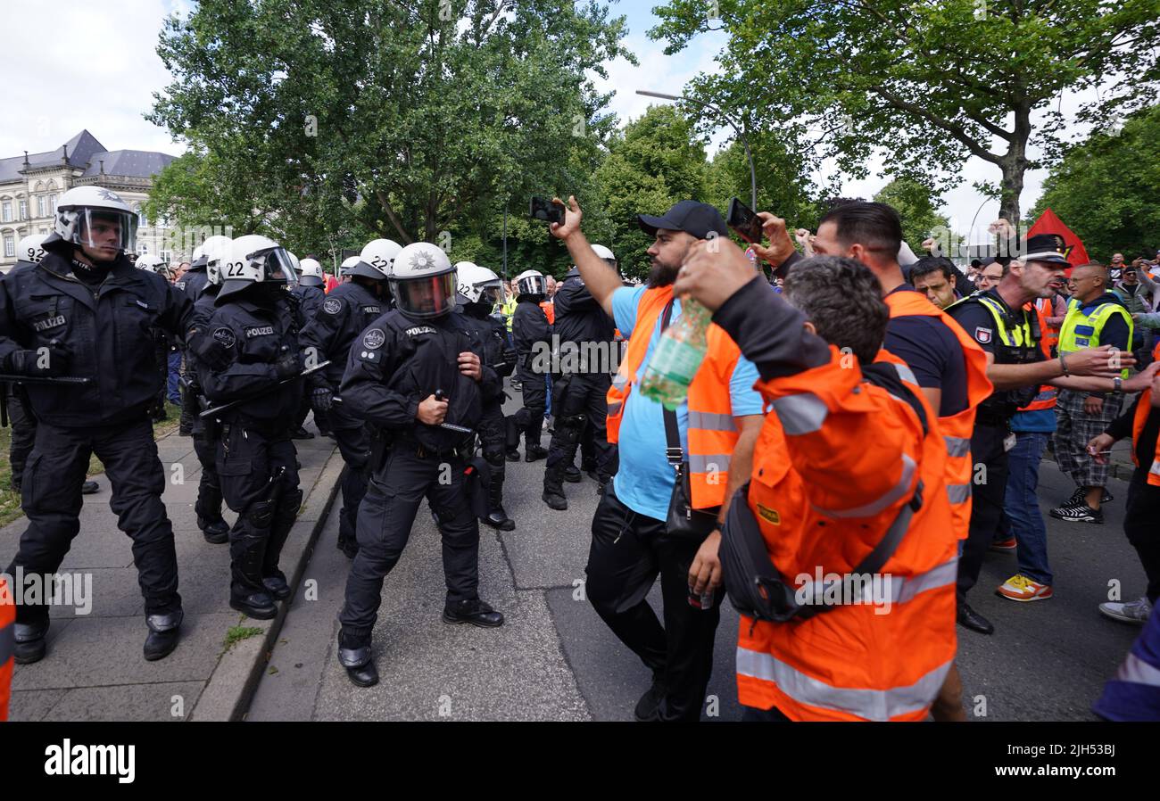 Hamburg, Deutschland. 15.. Juli 2022. Polizisten werden von Demonstranten zurückgedrängt, nachdem sie einen Teilnehmer einer Hafenarbeiterdemonstration vor der Gewerkschaftshalle in der Innenstadt festgenommen haben. Kredit: Marcus Brandt/dpa/Alamy Live Nachrichten Stockfoto