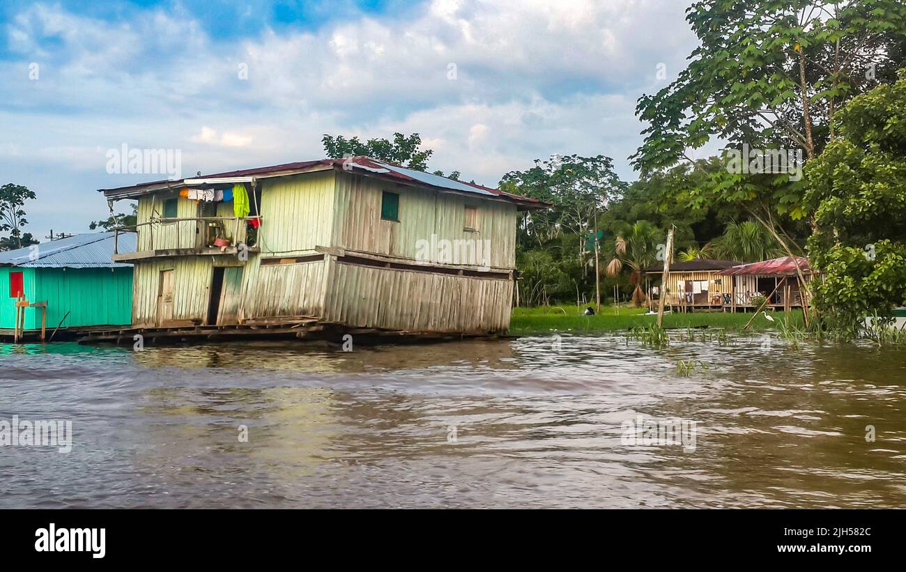 Puerto Narino, Kolumbien - 13. Februar 2017: Armes hölzernes schiefe Haus am Wasser. Favela Slums lokaler Indianerstämme. Stelzenhäuser auf Pfählen gebaut Stockfoto