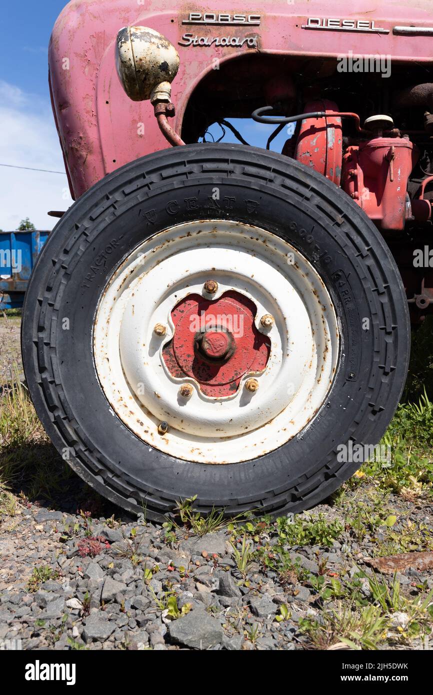 Vorderrad eines unrestaurierten roten Porsche Diesel Standard Traktors Stockfoto