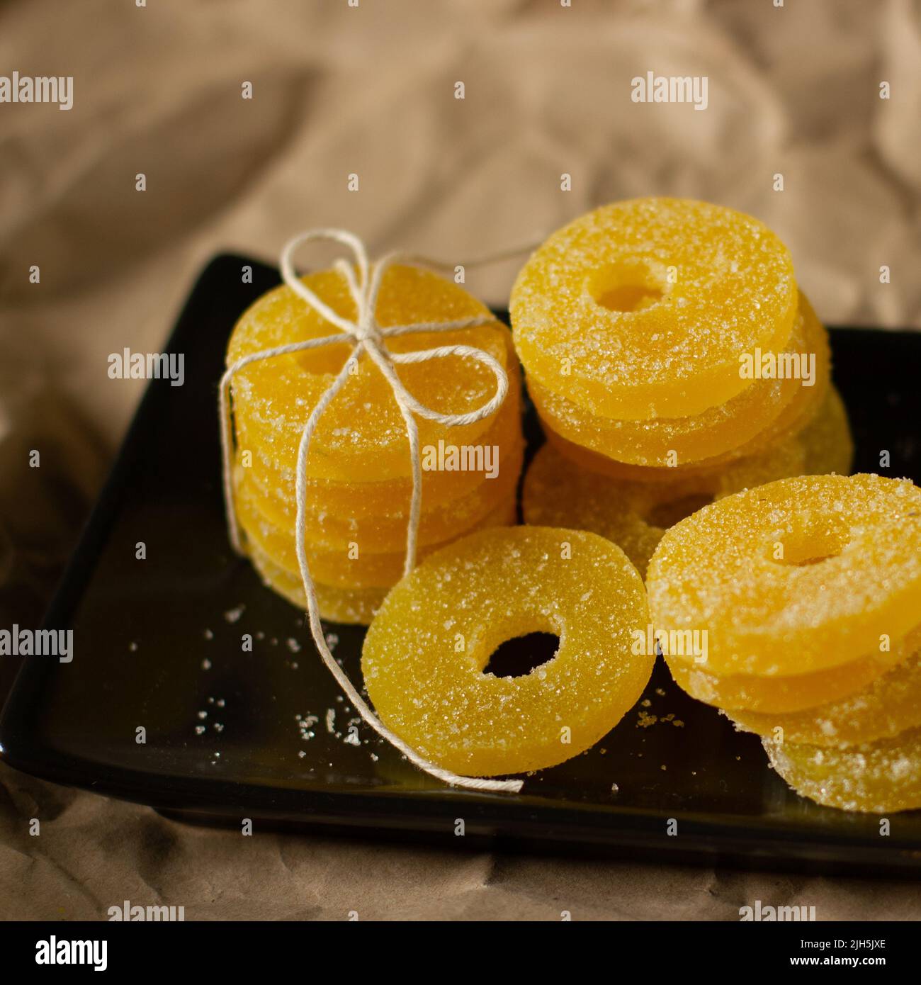Zitronen-, Orangen- und Grapefruitscheiben in Zucker isoliert auf einem hölzernen Hintergrund, Nahaufnahme. Marmelade Süßigkeiten. Süßigkeiten mit Zitrusgeschmack. Süßigkeiten Stockfoto