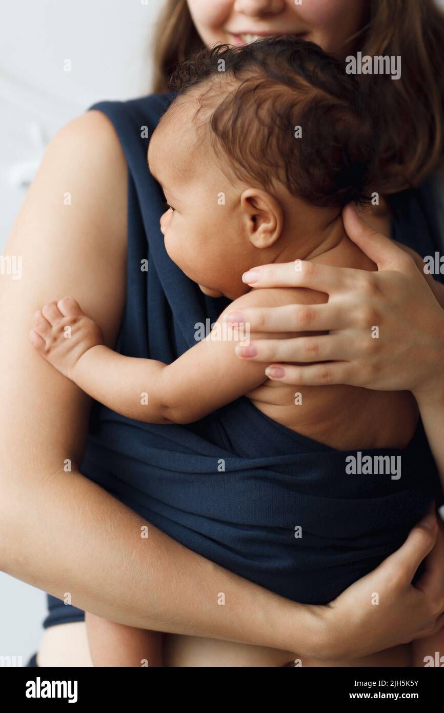 Mutter hält ihr Baby in einer Schlinge Stockfoto