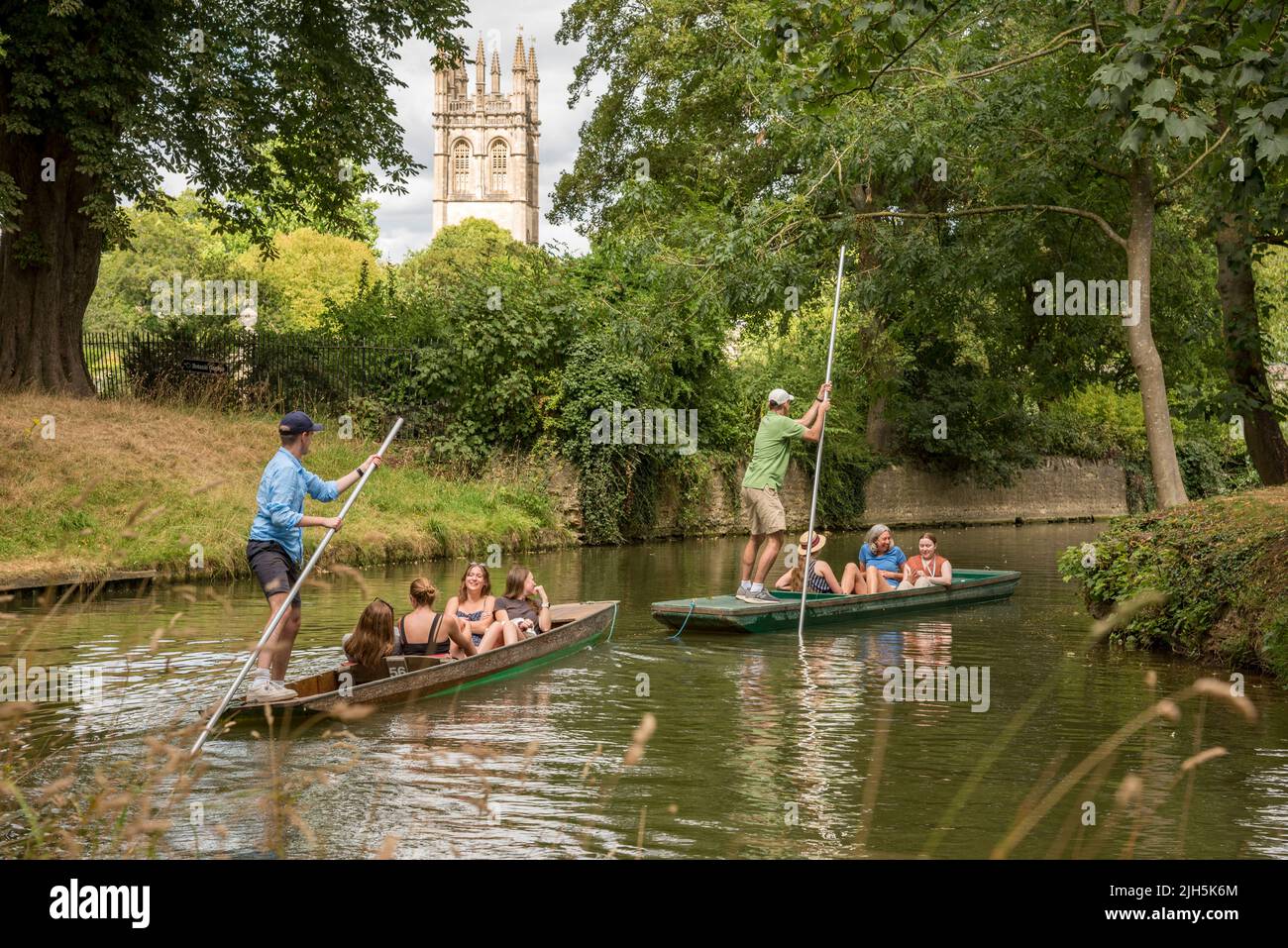 Oxford, Großbritannien. 15.. Juli 2022. Wetter in Großbritannien: Oxford, Großbritannien, 15.. Juli 2022. Während des heißen Wetters genießen die Menschen einen angenehmen Nachmittag beim Plagen auf dem Fluss Cherwell im Zentrum von Oxford, Großbritannien. Der Magdalenenturm ist durch die Bäume zu sehen. Das Punting ist eine Tradition in Oxford, die von Einheimischen, Studenten und Besuchern gleichermaßen genossen wird. Quelle: Martin Anderson/Alamy Live News Stockfoto