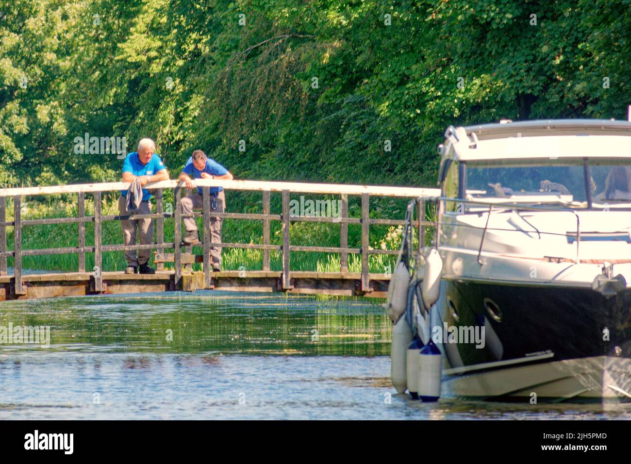 Bowling, Glasgow, Schottland, Großbritannien Juli 15. 2022. Wetter in Großbritannien: Sonniger Bowling-Hafen und Forth und clyde-Kanal bei clydebank, als das Wetter heiß wurde und die Einheimischen „Strohhähne“ oder Tops-Off-Wetter sahen. Kanalarbeiter warten auf einer Brücke, bevor sie das Loch öffnen, um das Boot passieren zu lassen. Credit Gerard Ferry/Alamy Live News Stockfoto