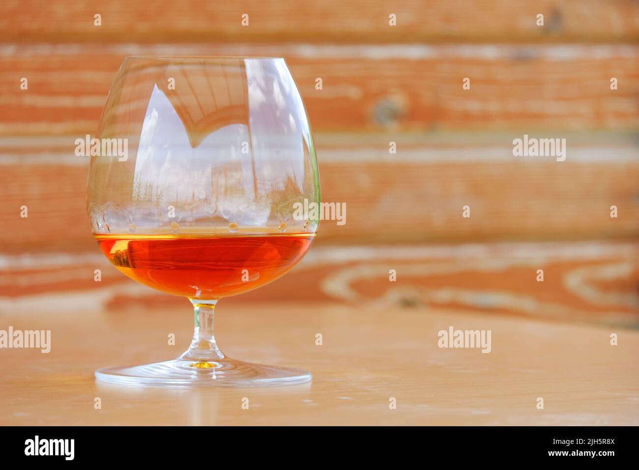 Whiskey und Cognac aus Snifter Cognac Glas mit Holzhintergrund Stockfoto