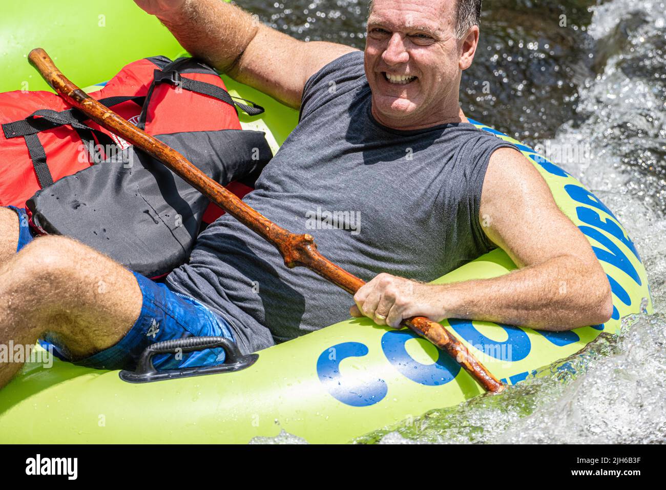 Lächelnder Vater, der mit seiner Familie in Helen, Georgia, einen Sommertag mit Tubing auf dem Chattahoochee River genießt. (USA) Stockfoto