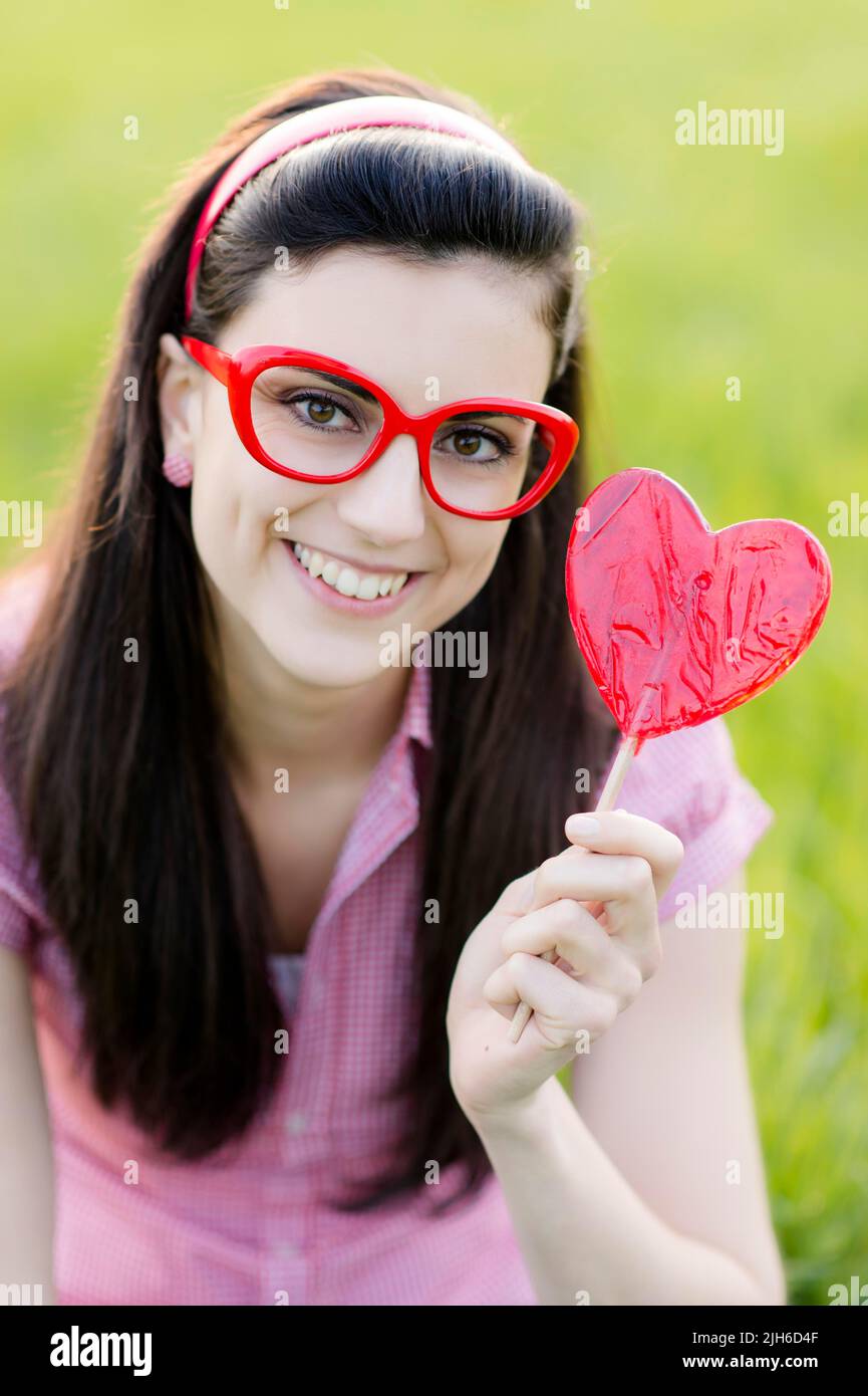 Frau mit Brille und Herz Lolly Stockfoto