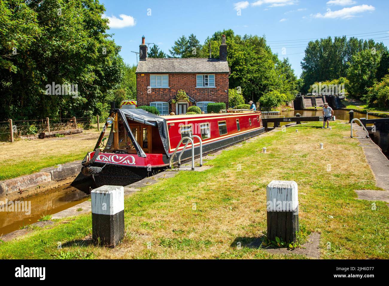 Canal Narrowboat fährt durch Schleusen auf dem Trent und Mersey Kanal, während es durch das Dorf Wheelock Cheshire England fährt Stockfoto