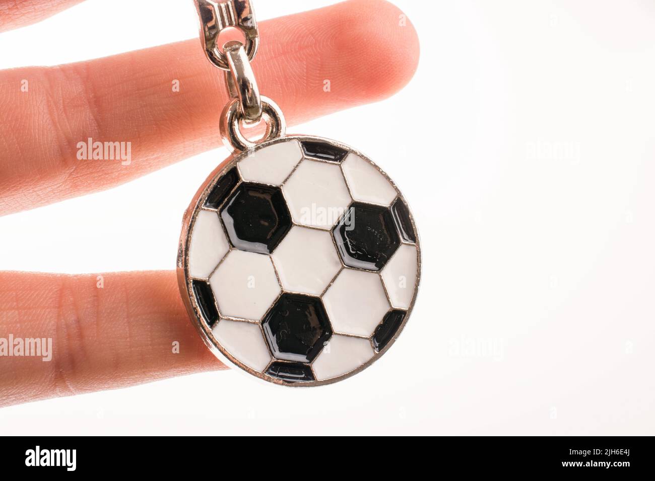 Fußball geprägt Schlüsselanhänger in der Hand auf einem weißen Hintergrund Stockfoto