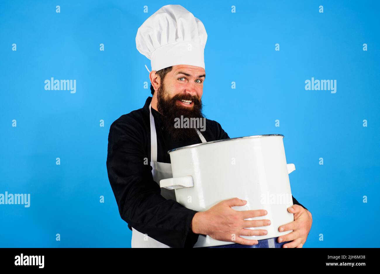 Professioneller Koch, Koch oder Bäcker mit Kochtopf in der Hand. Bärtiger Mann in Uniform mit Kochtopf Stockfoto