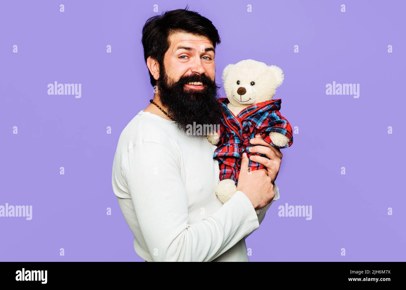 Lächelnder Mann mit Plüschtier. Geschenk zum Geburtstag. Bärtiger Typ mit Teddybär. Jahrestag, Feiertag. Stockfoto