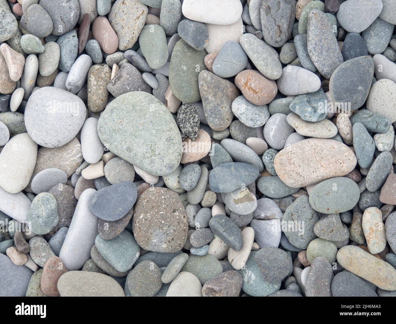 Große Steine am Strand. Hintergrund aus Steinen. Felsbrocken an der Küste. Glatte Pflastersteine. Meeresmotiv Stockfoto