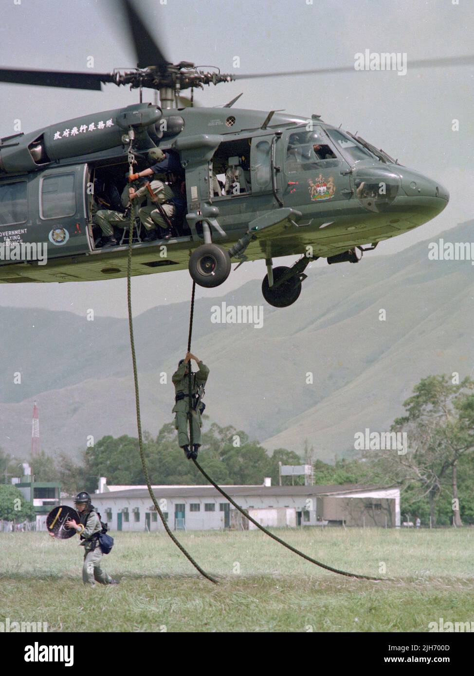 Police Tactical Unit, (Royal Hong Kong Police) Hubschraubertraining in Shek Kong, New Territories, Hong Kong im September 1993. HK Government Flying Services hatte den S-70 Black Hawk Hubschrauber. Die Polizei in der Bereitschaftsspanne springt oder springt vom schwebenden Black Hawk herunter. Stockfoto