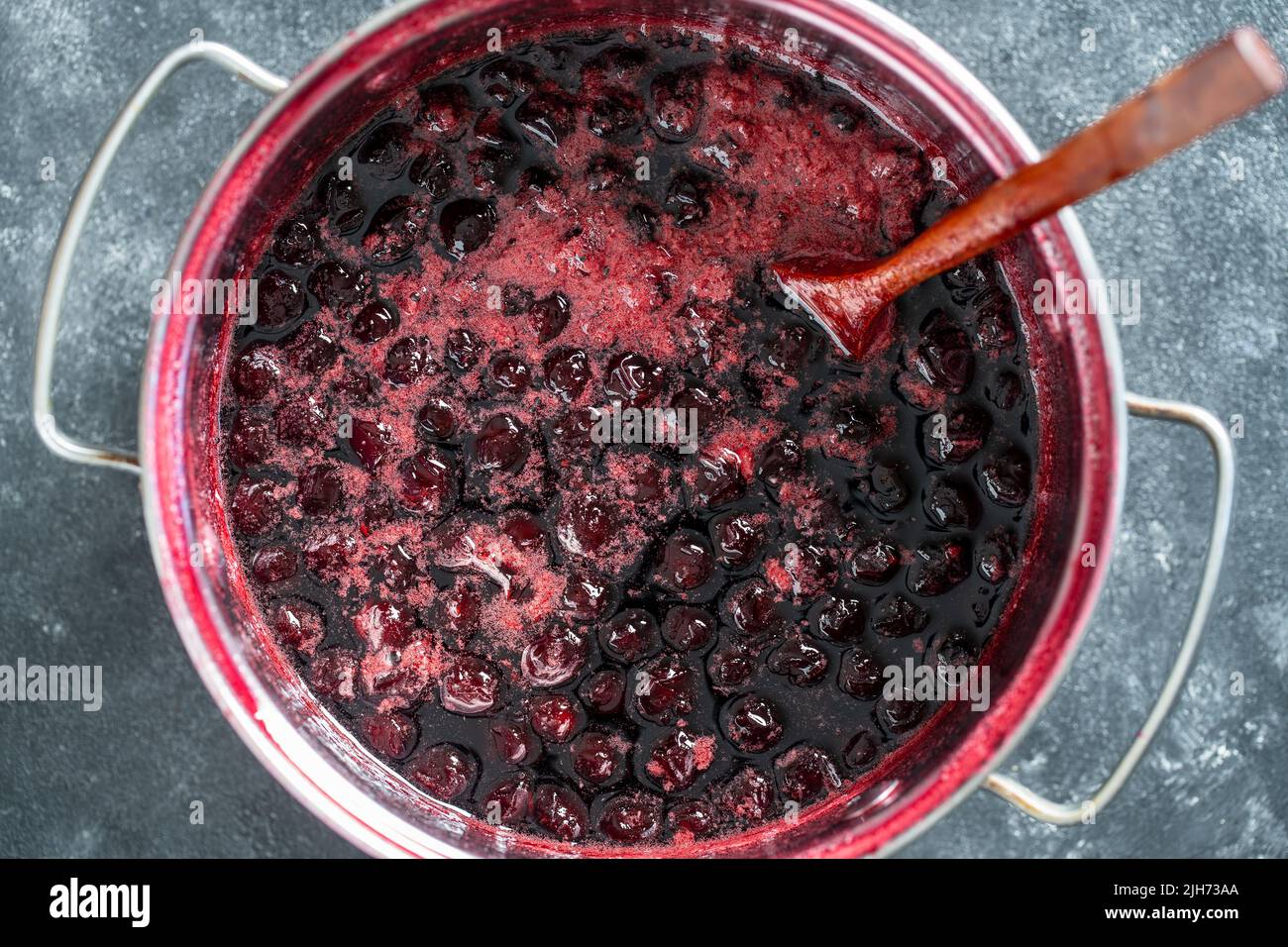Zubereitung von frisch gepflückten roten Kirschen mit Zucker zur Kirschmarmelade, Nahaufnahme, Draufsicht Stockfoto