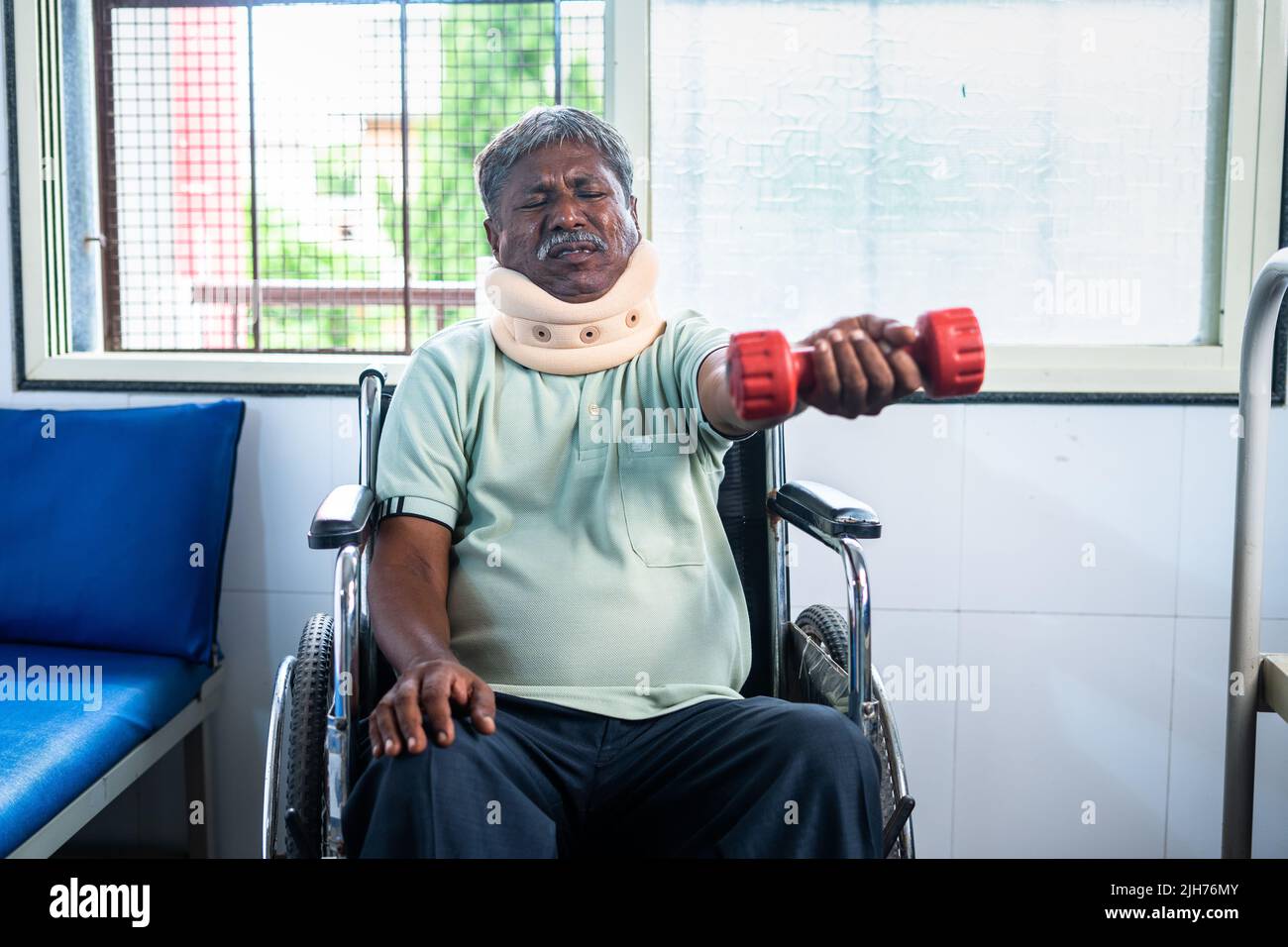 Verletzung Senior Mann mit Nackenband tun Hantel-Übung, während auf dem Rollstuhl im Krankenhaus - Konzept der Behandlung, Medicare und Entspannung Stockfoto