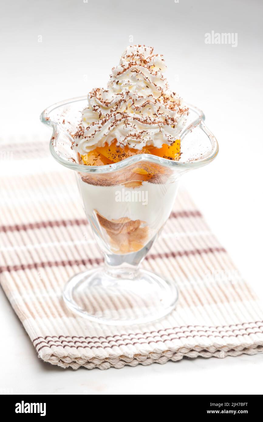 Eis mit geschmorten Pfirsich und Schlagsahne Stockfoto