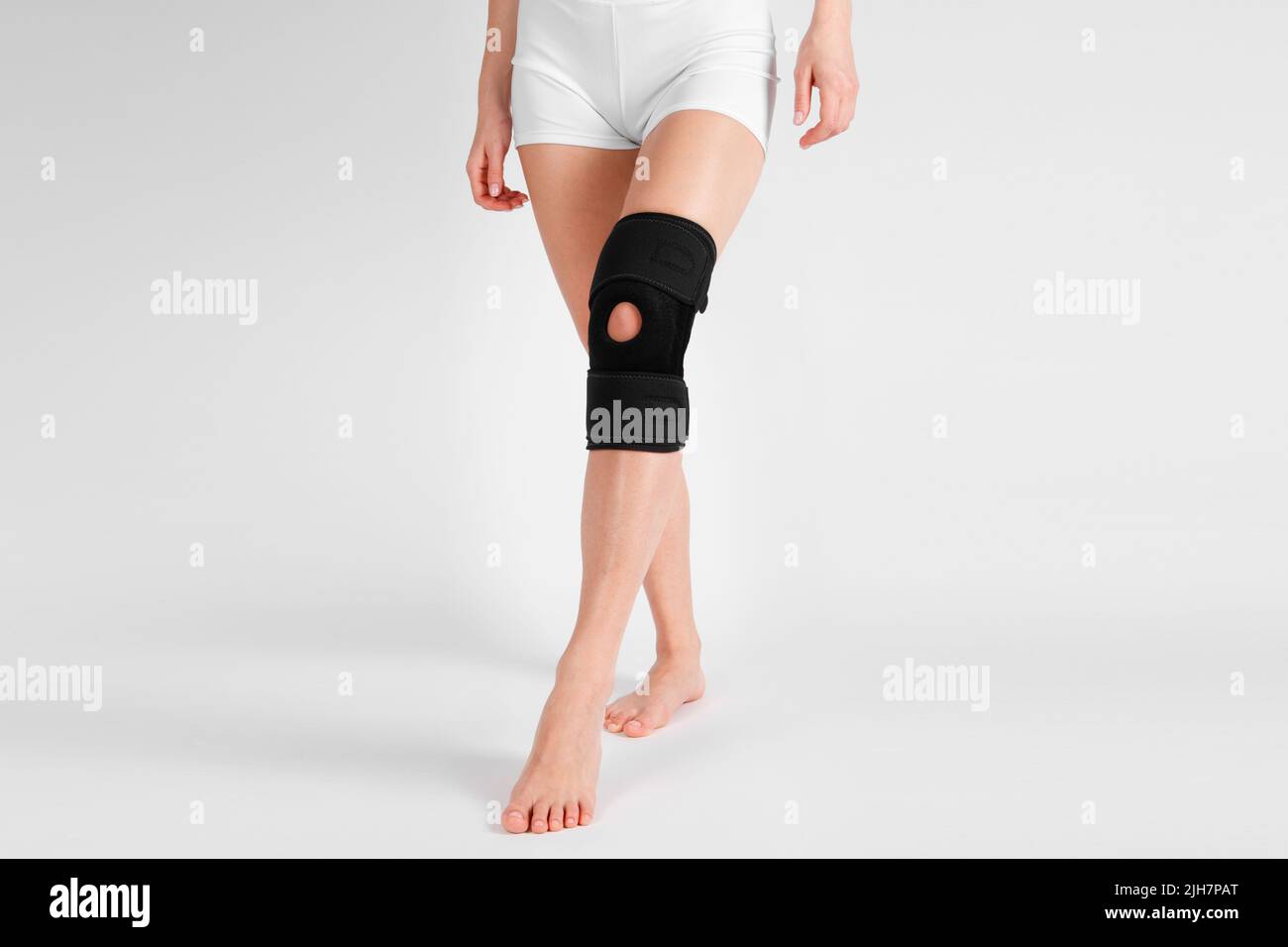 Kniestützenstrebe am Bein isoliert auf weißem Hintergrund. Elastische orthopädische Orthese. Anatomische Hosenträger für Kniefixierung, Verletzungen und Schmerzen. Schutz Stockfoto