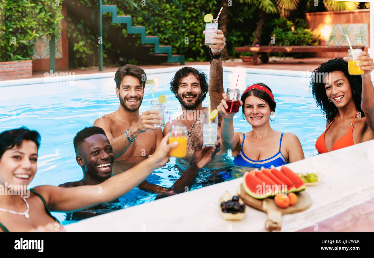 Multiethnische Gruppe von glücklichen Freunden trinkt und viel Spaß im Schwimmbad -Menschen im Sommer-und Urlaubskonzept - konzentrieren sich auf die ma in der Mitte Stockfoto