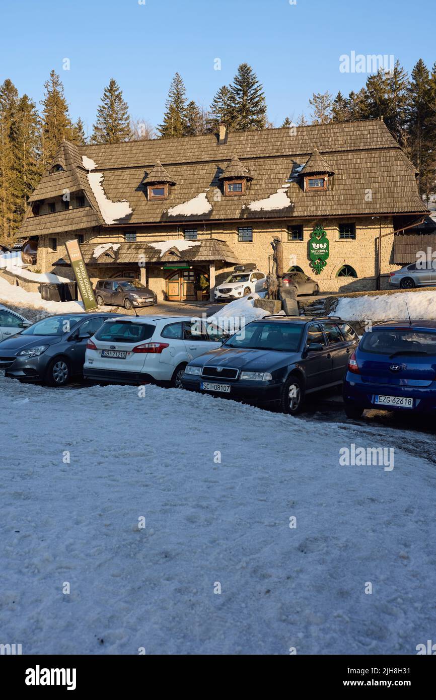 SZCZYRK, POLEN am 2022. MÄRZ: Gasthaus im schlesischen Beskiden-Gebirge auf der europäischen Bialy Krzyz, klarer blauer Himmel am kalten sonnigen Wintertag - senkrecht Stockfoto