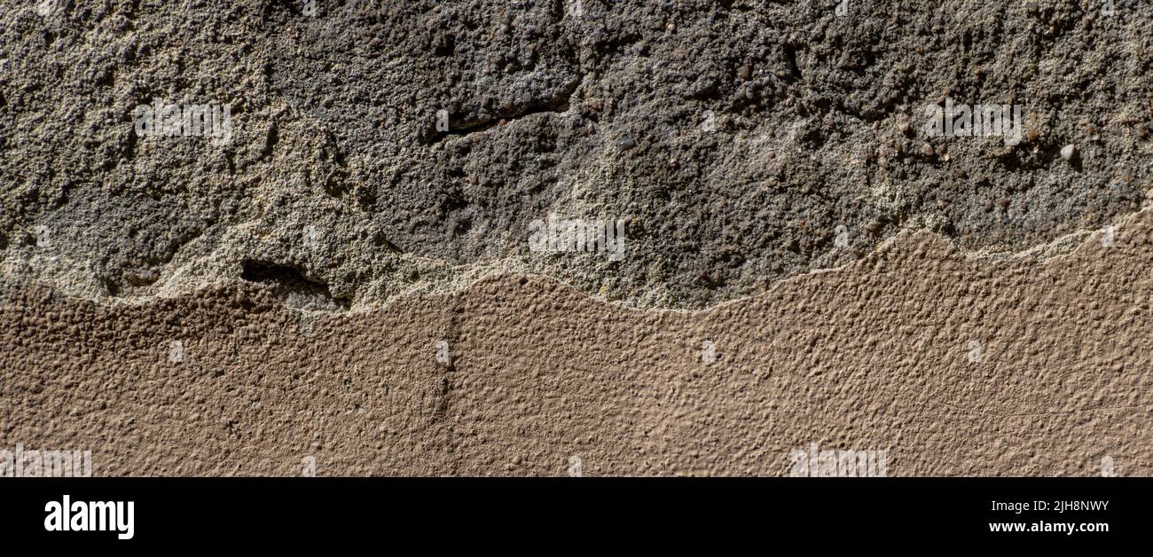 Alte Sandsteinwand mit dicken Gipsstücken abgebrochen Stockfoto