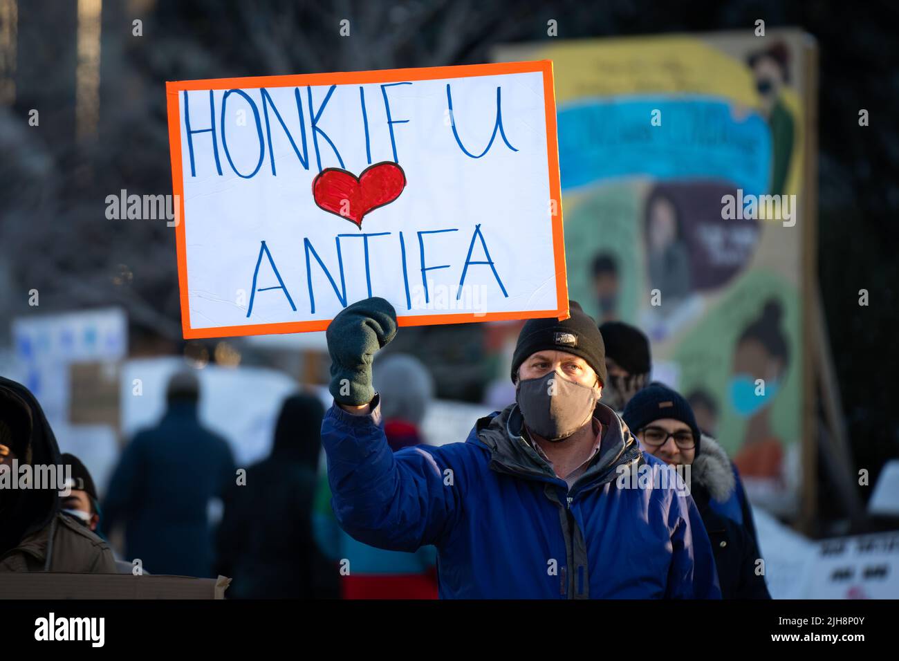 Ein Mann hält ein Schild mit dem Titel „Honk if you love Antifa“ bei einem Gegenprotest zum Konvoi „Freedom“ in Ottawa, Kanada. Februar 2022 Stockfoto