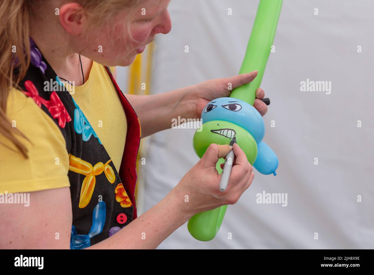 Wembley Park, London, Großbritannien. 16.. Juli 2022. Ballonkünstler in der Arena Square Kids Zone, wenn der International Busking Day zum Wembley Park zurückkehrt. Das kostenlose, ganztägige Festival hat große Namen, die sich auf 9 Bühnen mit aufstrebenden Künstlern und Basiskünstlern teilen. Die Veranstaltung im Wembley Park umfasst auch Bereiche für Familienspaß mit Zirkusworkshops, Magie- und Comedy-Acts, Eskapologenroutine, Gesichtsbemalung und Ballonkünstler. Der internationale Bucking Day, der vom Bürgermeister von London unterstützt wird, wird von Busk in London präsentiert. Amanda Rose/Alamy Live News Stockfoto