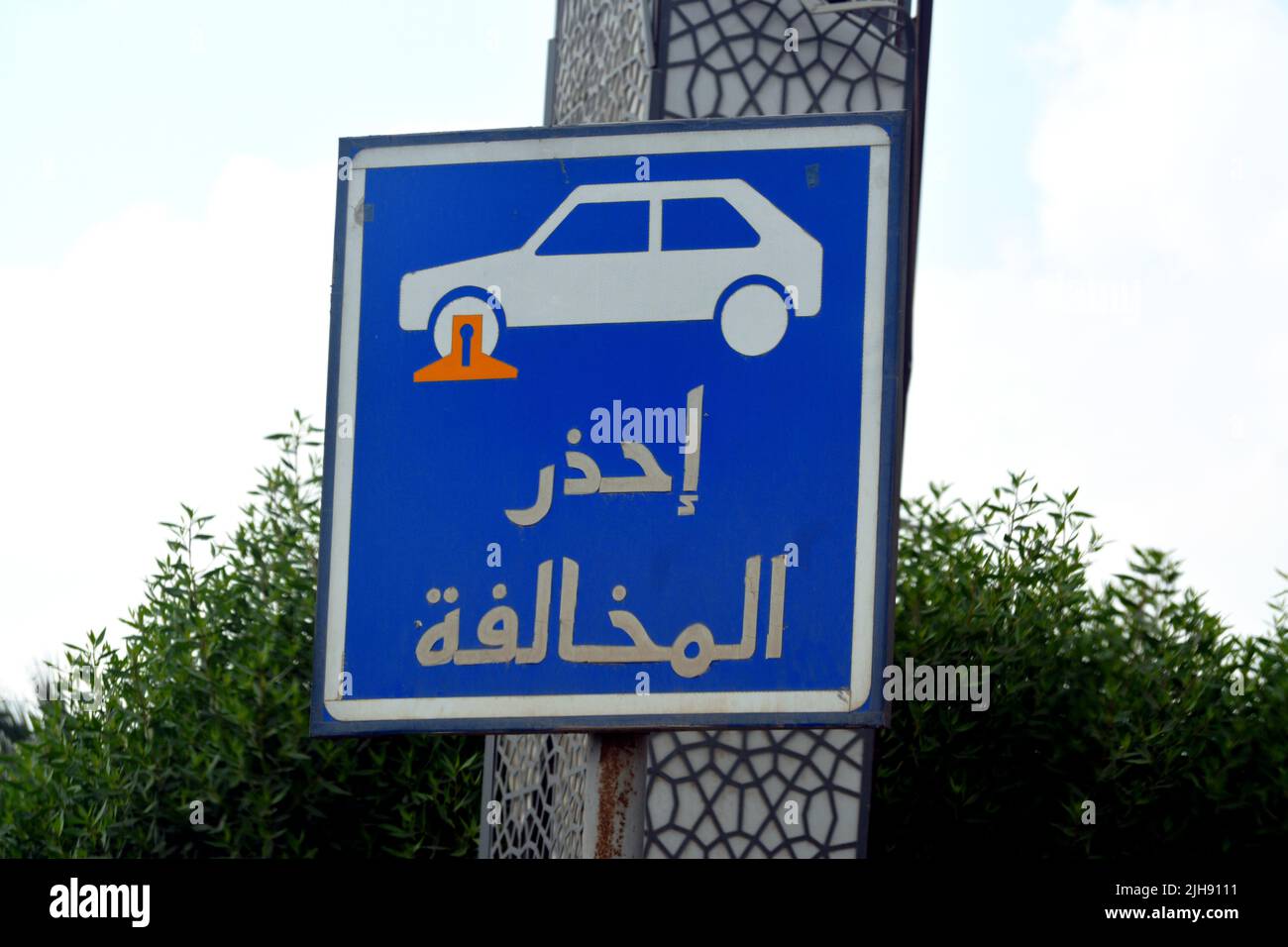 Übersetzung der arabischen Inschrift (Vorsicht vor Verkehrsverstößen), ein Verkehrsschild zeigt einen Sperrbereich für das Parken der Fahrzeuge und ein Auto mit einem Stockfoto