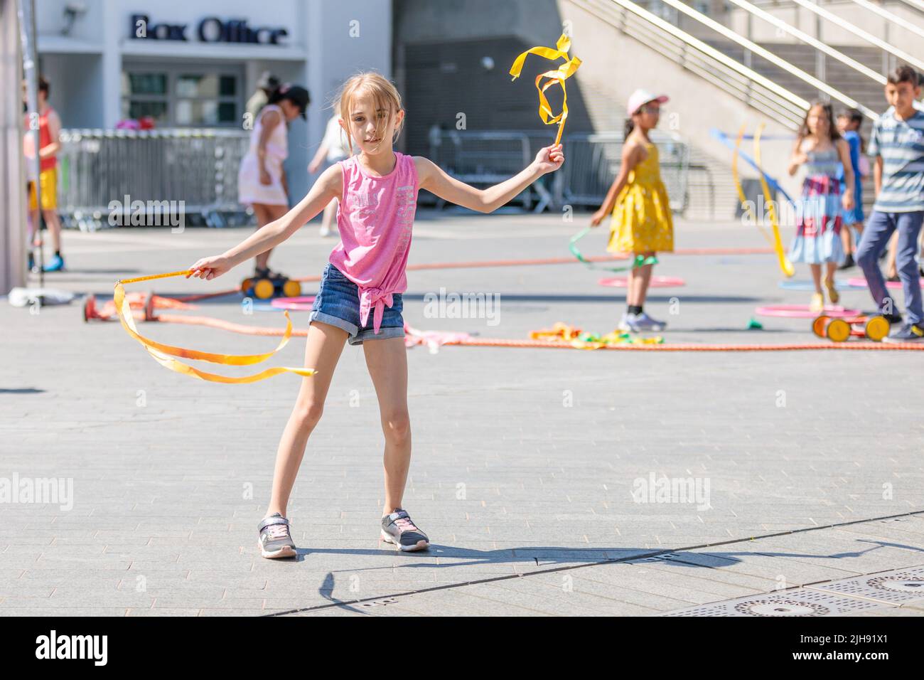 Wembley Park, London, Großbritannien. 16.. Juli 2022. Familien lernen beim Zirkus-Skills-Workshop, wenn der International Busking Day wieder im Wembley Park ist. Das kostenlose, ganztägige Festival hat große Namen, die sich auf 9 Bühnen mit aufstrebenden Künstlern und Basiskünstlern teilen. Die Veranstaltung im Wembley Park umfasst auch Bereiche für Familienspaß mit Zirkusworkshops, Magie- und Comedy-Acts, Eskapologenroutine, Gesichtsbemalung und Ballonkünstler. Der internationale Bucking Day, der vom Bürgermeister von London unterstützt wird, wird von Busk in London präsentiert. Amanda Rose/Alamy Live News Stockfoto