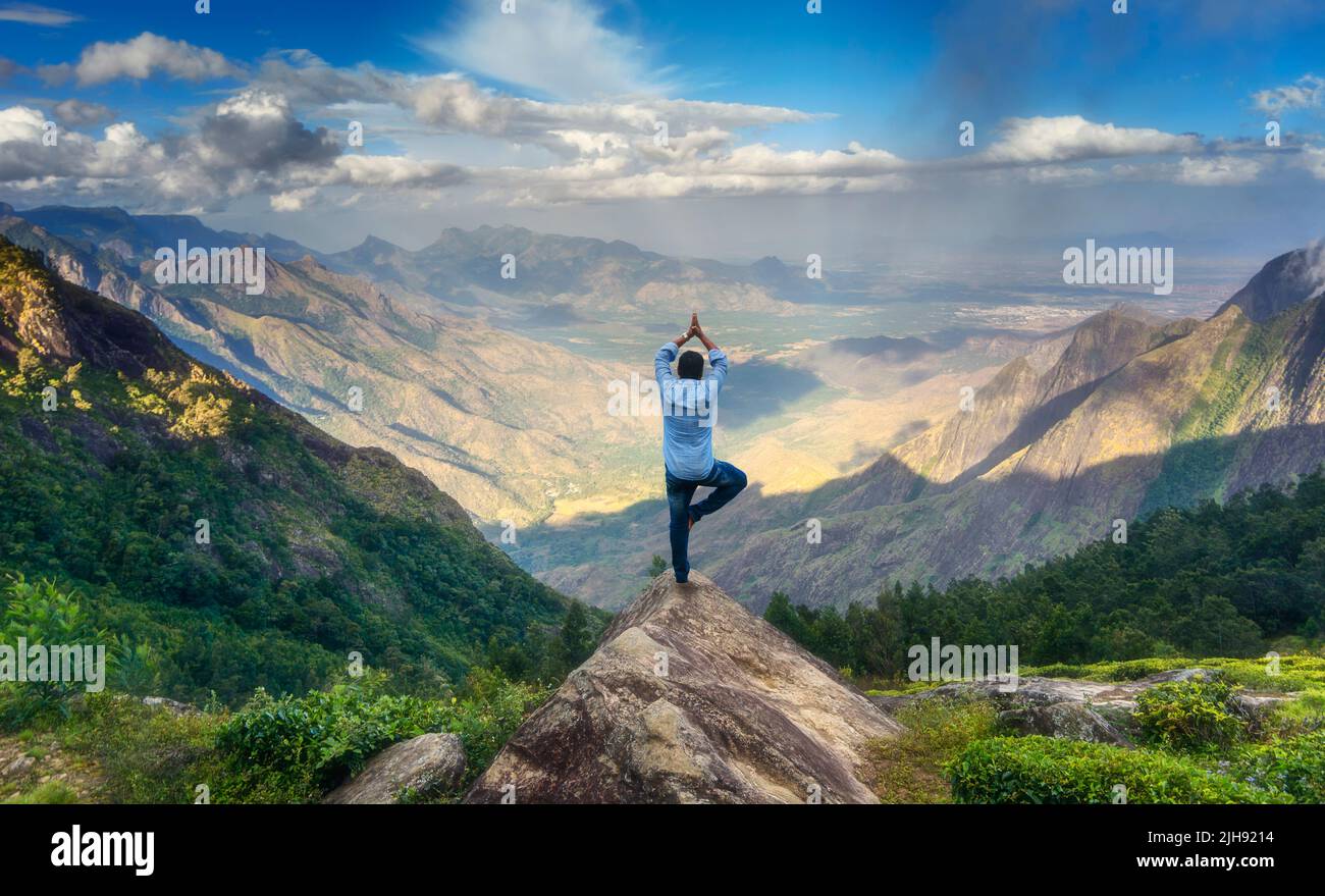 Mann, der Yoga auf dem Gipfel des Berges in Kolukkumalai, Tamilnadu, Indien, durchführt Stockfoto