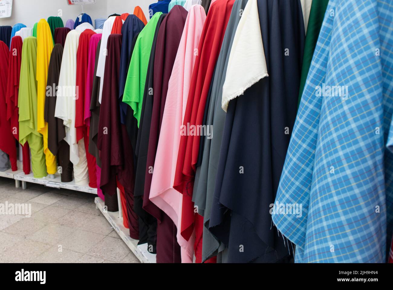 Stapel von mehreren bunten kleiden Rollen Stoff Batch zum Verkauf in einem Textilgeschäft Shop Stockfoto