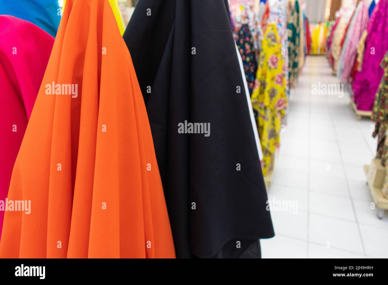 Stapel von mehreren bunten kleiden Rollen Stoff Batch zum Verkauf in einem Textilgeschäft Shop für halloween Stockfoto