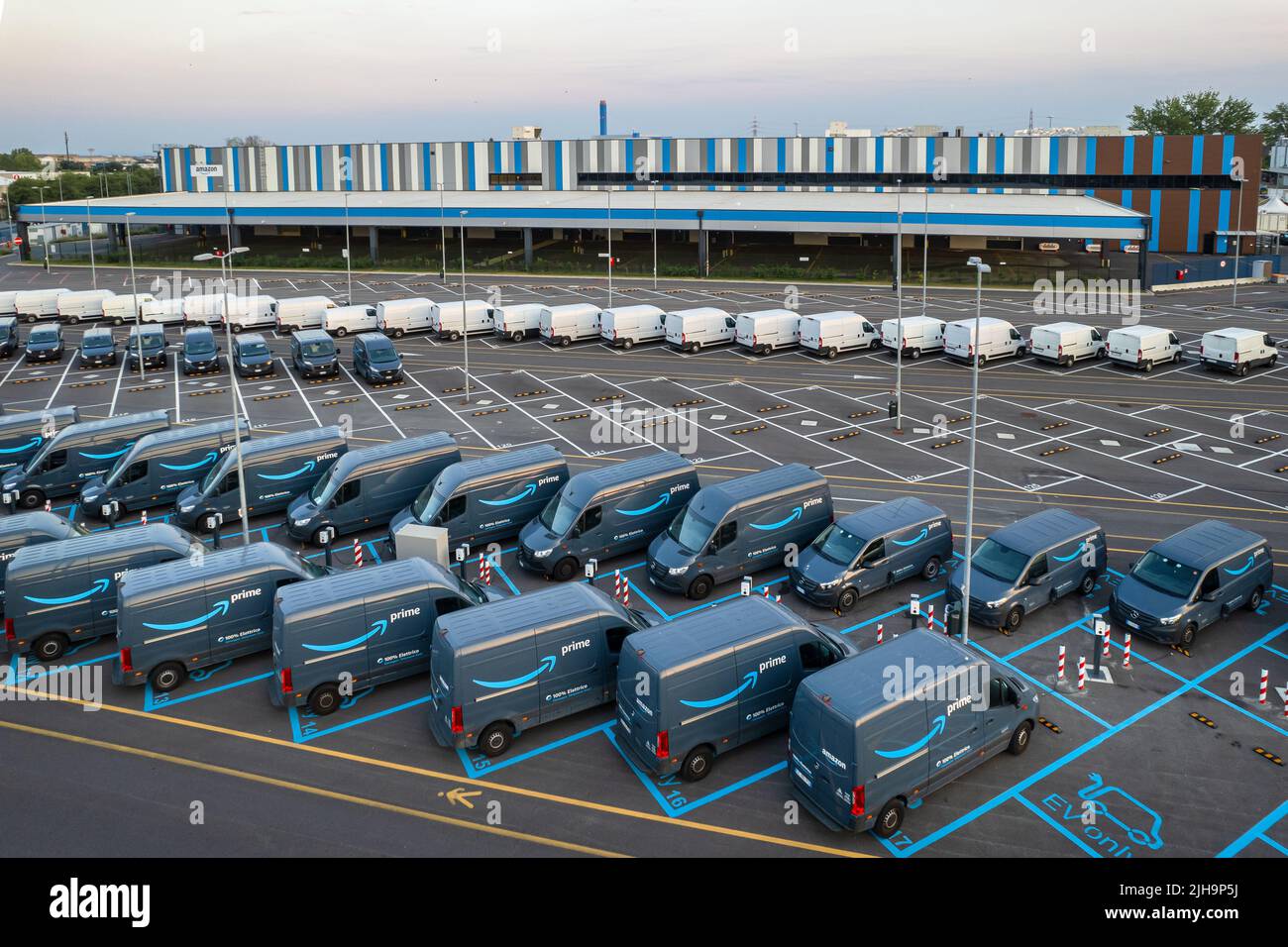 Draufsicht auf die elektrischen Lieferwagen von Amazon Prime, die am Logistikzentrum von Amazon geparkt sind. Turin, Italien - Juli 2022 Stockfoto