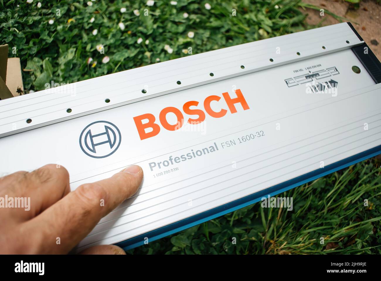 Paris, Frankreich - 29. Apr 2022: Außenansicht POV-Außenhand zeigt auf die Bosch Professional Führungsschiene mit 32-Loch-Anordnung, 1600 mm langes Modell FSN 1600 32 direkt nach dem Auspacken Stockfoto