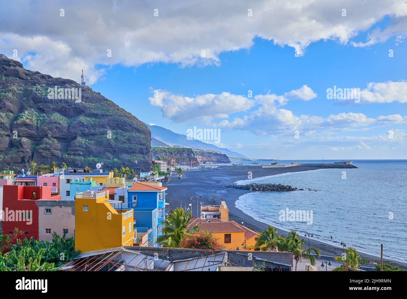 Eine farbenfrohe und lebendige Stadt Hafen von Tazacorte, La Palme, Spanien. Schöne Landschaft einer Stadt in der Nähe des Strandes und der Berge mit einem bewölkten Blau Stockfoto