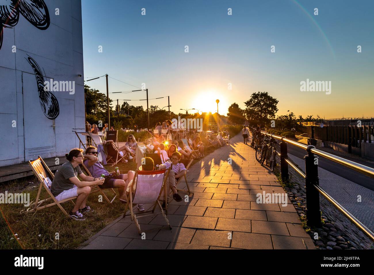 Personen, die bei Sonnenuntergang auf Liegestühlen sitzen, Paloma nad Wisłą im Museum für Moderne Kunst (Muzeum Sztuki Nowoczesnej w Warszawie), Powiśle, Warschau, Polen Stockfoto